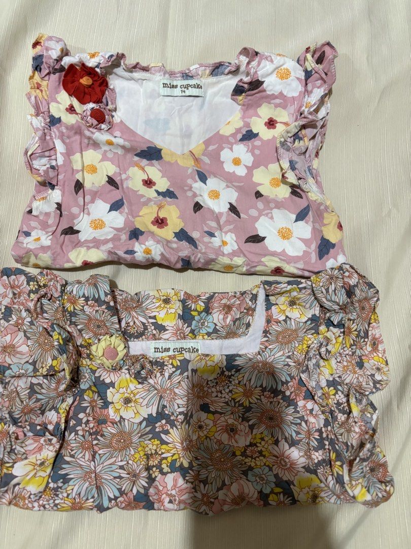 Miss Cupcake Floral Tops (Size 14) (Category: Babies & Kids Fashion) located in Makati City. Submitted by issa124 (Listing ID 1464311273, Image 1). Description: - Two adorable floral tops from Miss Cupcake - Size 14 - Pink top: V-neck with red flower detail - Grey top: Square neckline - Both tops feature charming ruffled sleeves - Versatile for everyday wear or special occasions - Your little one will surely love these! - chest :13 inches when la