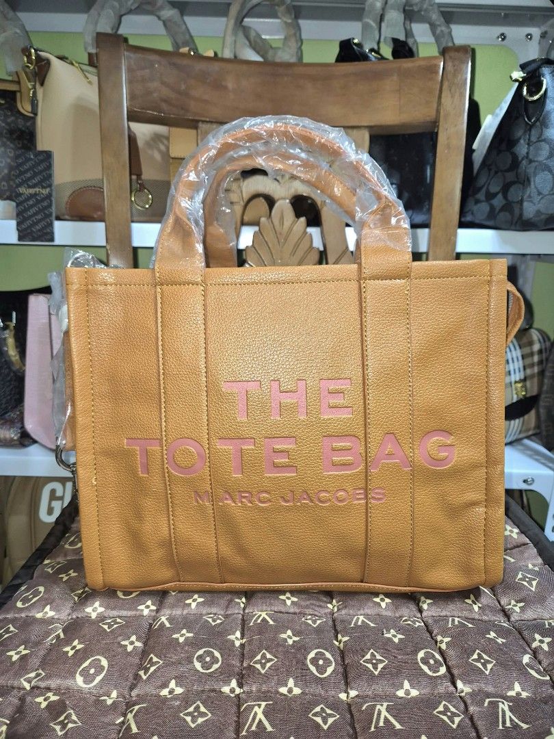 MJ The Tote Bag - Orange Leather (Category: Tote Bags) located in Manila. Submitted by mysticfox.9b1678 (Listing ID 1464267565, Image 1). Description: - MJ 'The Tote Bag' - Vibrant orange leather - 'The Tote Bag' and 'Marc Jacobs' in stylish pink lettering - Spacious interior, ideal for everyday essentials or travel - Versatile for daily use.
