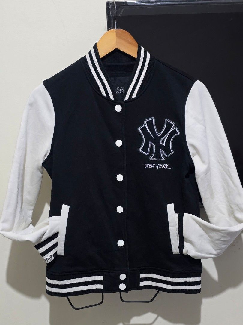 MLB New York Yankees Varsity Jacket (Category: Coats, Jackets and Outerwear) located in Baguio. Submitted by sonny14 (Listing ID 1464189669, Image 1). Description: - Classic black and white varsity jacket - Features iconic New York Yankees logo on the front - MLB and Major League Baseball branding - Easy button-up closure - Comfortable ribbed cuffs and hem - Size Medium (M) - Ideal for any dedicated Yankees fan.