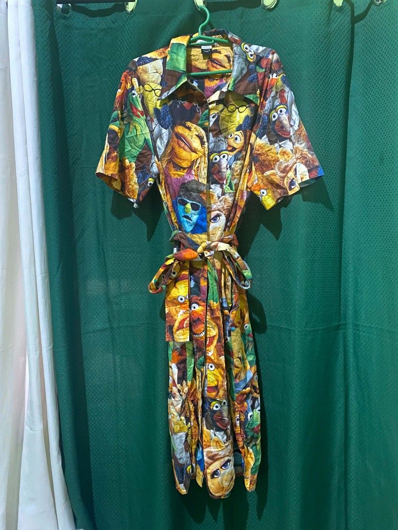 Muppet Characters Print Button-Up Shirt Dress with Belt (Category: Dresses) located in Quezon City. Submitted by elihur.tuazon (Listing ID 1464299727, Image 2). Description: - Vibrant dress featuring a fun Muppet character print. - Short sleeves and a classic collared neckline. - Includes a matching fabric belt to define your waist. - Ideal for everyday casual wear or a unique themed party outfit. - Stand out with this one-of-a-kind print!.