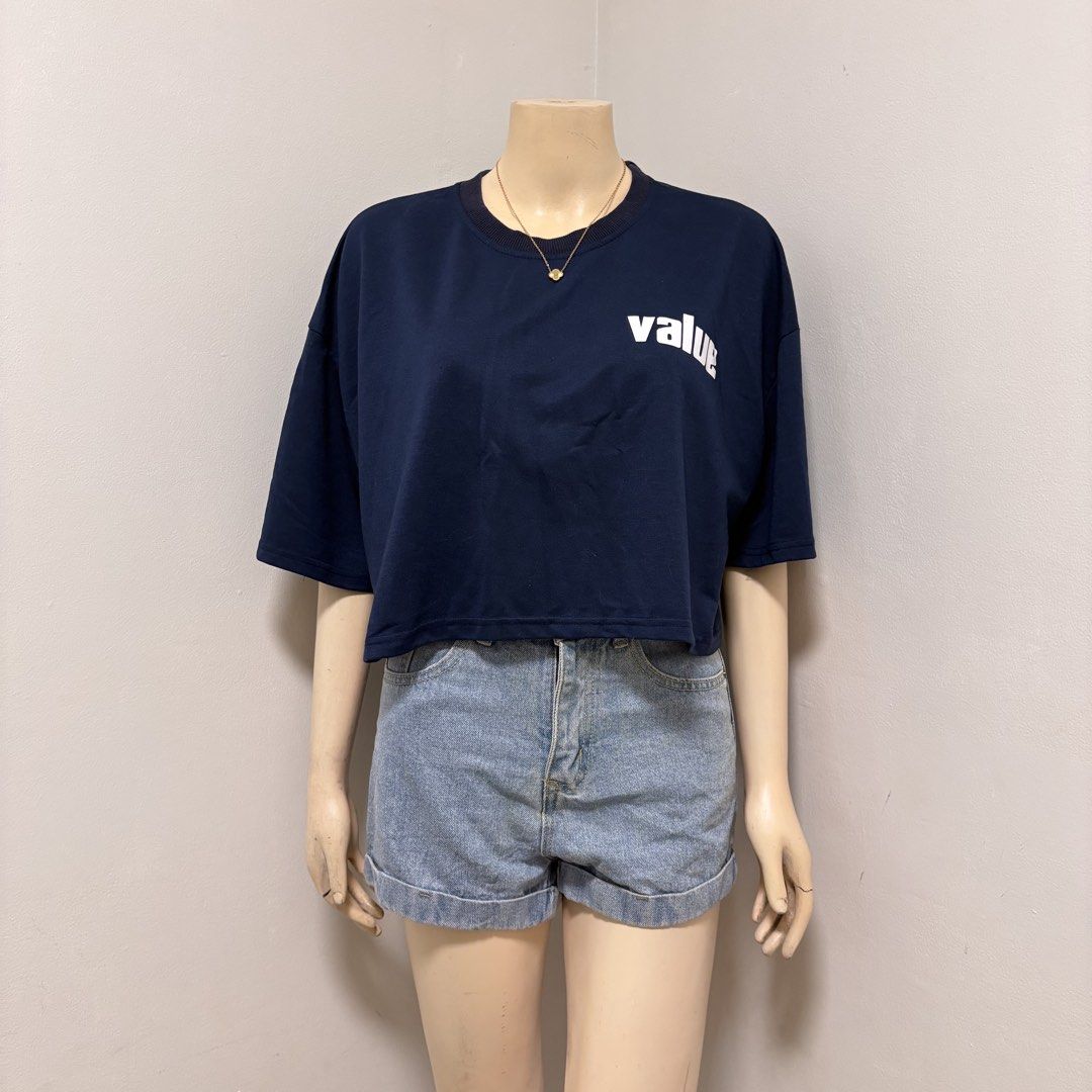 Navy Blue Crop Top (Category: Shirts) located in Imus. Submitted by reloved.nd (Listing ID 1464261046, Image 1). Description: - Navy blue cropped t-shirt - Features a white 'value' graphic on the front - Short sleeves - Relaxed fit - Easy to style with denim shorts or jeans for a casual look.