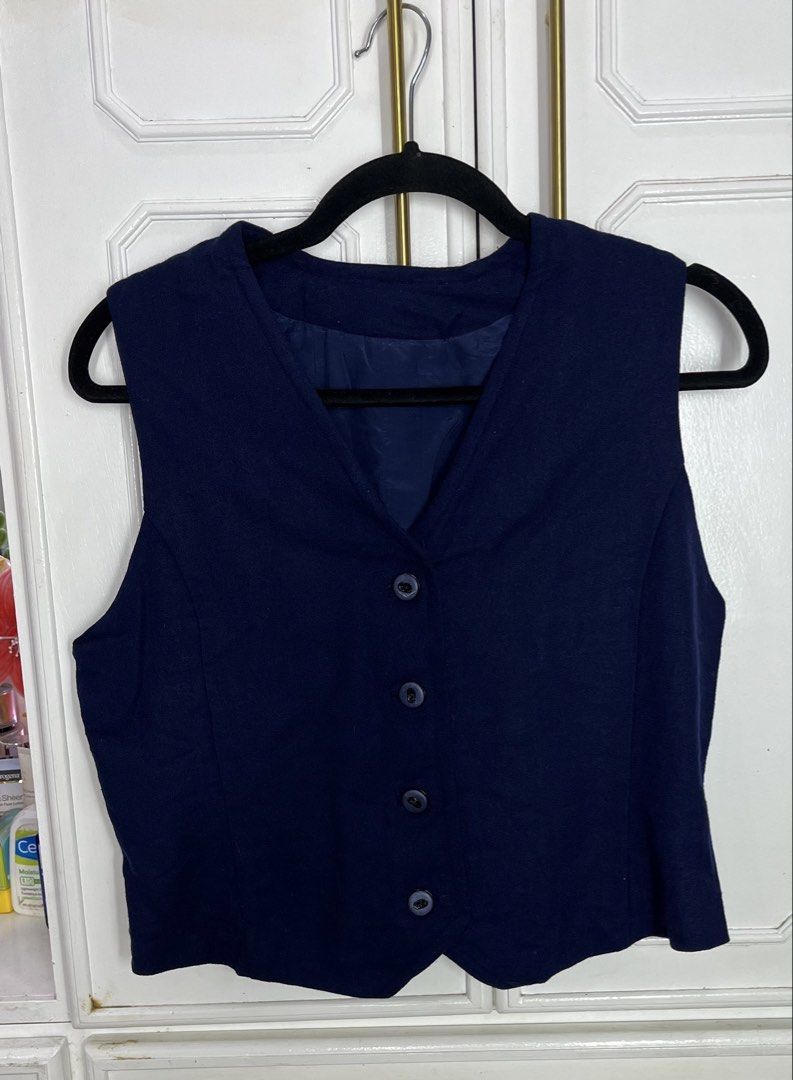 Navy Blue V-Neck Button-Up Vest (Category: Sleeveless) located in Pakil. Submitted by roserarela (Listing ID 1464265682, Image 1). Description: - Classic navy blue vest - V-neckline - Button-up front - Fully lined interior - Ideal for layering over shirts or dresses - Versatile for smart casual or formal outfits - Simple and timeless design -can fit small to medium Measurements: From shoulder to hem: 48cm Bust: 50cm.