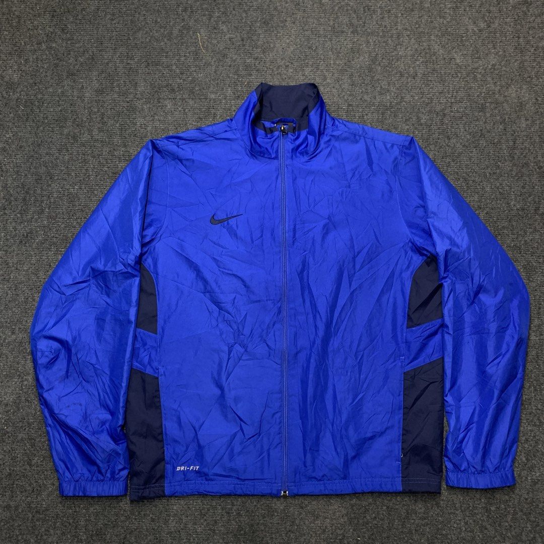 Nike Dri-FIT Blue Track Jacket (Category: Coats, Jackets and Outerwear) located in Imus. Submitted by la.wigginss0 (Listing ID 1464141060, Image 1). Description: - Blue Nike Dri-FIT jacket - Lightweight and breathable fabric - Features iconic Nike swoosh logo - Dark navy blue side panels - Full zip closure - Elasticated cuffs and hem - Ideal for sports or casual wear.