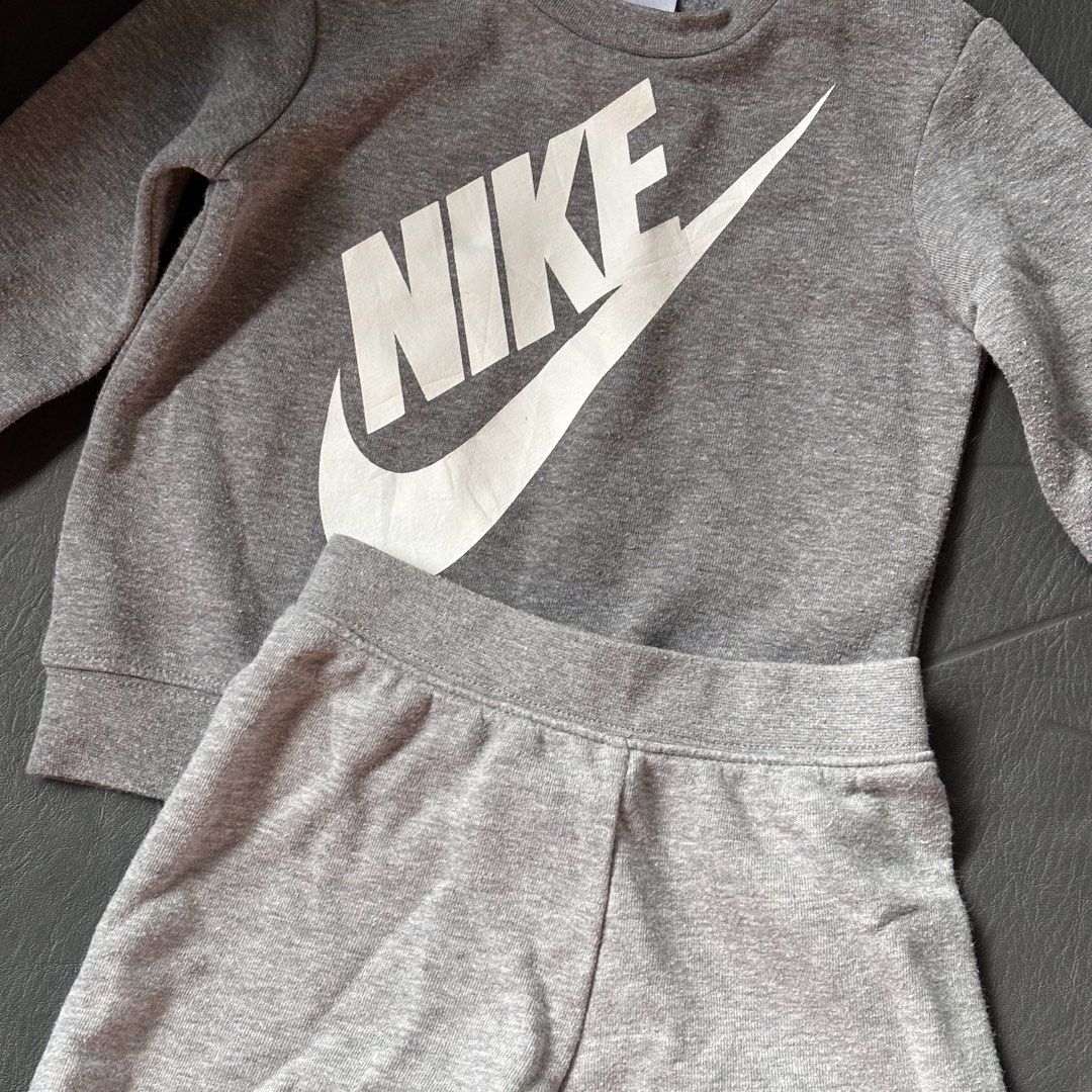 Nike Grey Sweatshirt and Shorts Set (Category: Babies & Kids Fashion) located in Mati. Submitted by sharieeng (Listing ID 1464146686, Image 2). Description: - Grey Nike tracksuit for kids - Includes long-sleeved sweatshirt with large white Nike logo - Matching shorts with smaller Nike logo on the leg - Comfortable and casual set - Ideal for everyday wear and active kids.