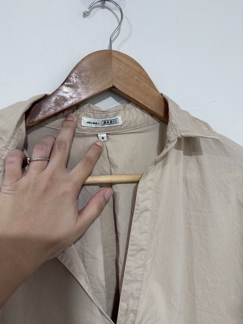Niko And… Beige Office Top (Category: Others Tops) located in Manila. Submitted by morningthrifters (Listing ID 1464219712, Image 2). Description: niko and... beige oversized skipper shirt. It features a relaxed silhouette with wide half-sleeves and an open, buttonless v-neckline typical of classic Japanese utility and city-casual styles. Similar variations of this shirt often feature a subtly wired structured collar or a comfortable cotton-linen