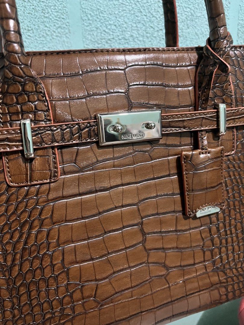 Nine West Brown Croc Embossed Tote Bag (Category: Tote Bags) located in Bulacan. Submitted by newfalcon_8ad33c (Listing ID 1464249536, Image 3). Description: - Stylish brown tote bag with a luxurious croc-embossed texture. - Elegant silver hardware details add a touch of sophistication. - Comfortable top handle for easy carrying. - Secure clasp closure keeps your belongings safe. - Includes a charming small hanging tag. - Ample interior space, id