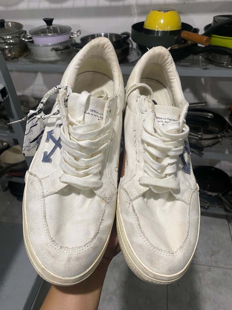 Off-White Low Top Canvas Sneakers Size 44 (Category: Sneakers) located in Bacolod City. Submitted by rimboythrift (Listing ID 1464194588, Image 1). Description: - Brand: Off-White - Type: White Canvas Low Top Sneakers - Size: 44 - Features: Iconic arrow logo on side, diagonal stripes on heel, Off-White logo on insole - Origin: Made in Indonesia - Condition: Shows some signs of wear on sole and canvas - NEED WASH .