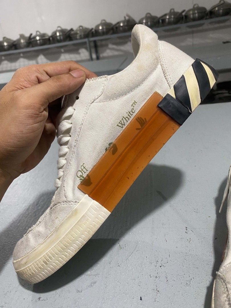 Off-White Low Top Canvas Sneakers Size 44 (Category: Sneakers) located in Bacolod City. Submitted by rimboythrift (Listing ID 1464194588, Image 3). Description: - Brand: Off-White - Type: White Canvas Low Top Sneakers - Size: 44 - Features: Iconic arrow logo on side, diagonal stripes on heel, Off-White logo on insole - Origin: Made in Indonesia - Condition: Shows some signs of wear on sole and canvas - NEED WASH .