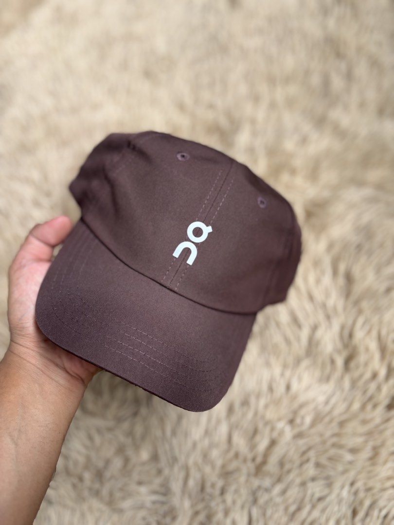 On Running Cap Brown (Category: Caps & Hats) located in Quezon City. Submitted by nojthrift (Listing ID 1464252090, Image 2). Description: - Brand: On Running - Color: Brown - Design: Simple with white logo on the front - Features: Adjustable strap at the back for a customized fit - Versatile: Ideal for everyday wear or sports activities - Style: Clean and classic look.
