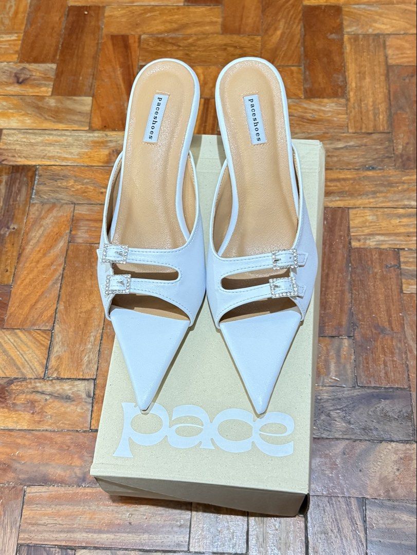 Pace Shoes from BKK - Trixie in White (Category: Heels) located in Quezon City. Submitted by najamazing (Listing ID 1464195909, Image 3). Description: - Brand: Paceshoes - Style: White pointed toe mules - Features: Double buckle detail at the front, slip-on style - Heel: 2 inches - Comfort: Comfortable for everyday wear - Includes: Original box - Original Price: $185 including shipping fee.