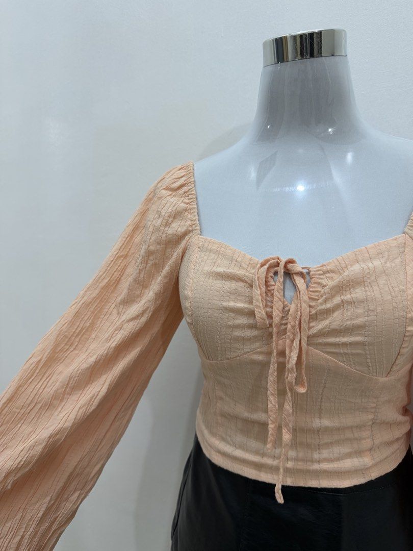 Peach Square Neck Tie Front Long Sleeve Top (Category: Longsleeves) located in Manila. Submitted by e.louise (Listing ID 1464334559, Image 2). Description: - Adorable peach top - Flattering square neckline - Chic tie-front detail - Stylish long puff sleeves - Textured fabric for added appeal - Versatile: pairs well with skirts or jeans - A must-have addition to your wardrobe.