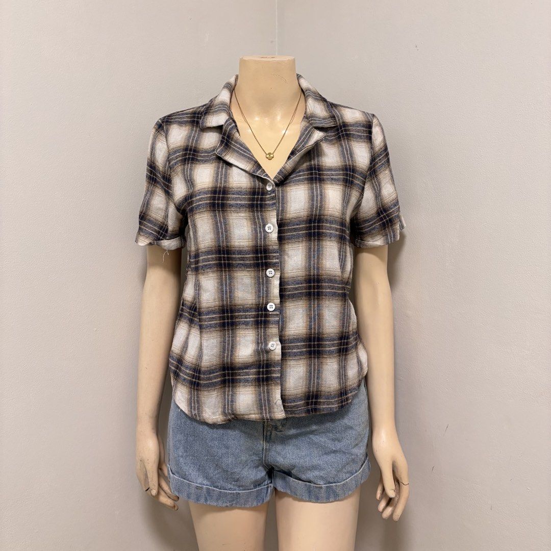Plaid Short Sleeve Buttondown Polo (Category: Shirts) located in Imus. Submitted by reloved.nd (Listing ID 1464261047, Image 1). Description: - Cute plaid design - Short sleeves - Features a collar - Button-up front - Versatile: pairs well with denim shorts or jeans - Lightweight material, ideal for warm weather - Easy to style for a casual look.