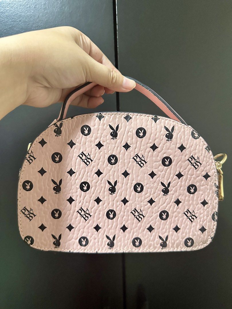 Playboy Bunny Pink Monogram Mini Handbag (Category: Luxury Bags & Wallets) located in Manila. Submitted by biskybysh (Listing ID 1464347111, Image 2). Description: - Adorable pink Playboy mini handbag - Features all-over bunny and 'PL BY' monogram print - Stylish gold hardware with Playboy zipper pulls - Includes a convenient top handle - Comes with a detachable strap for versatile carrying - Ideal for carrying your daily essentials.
