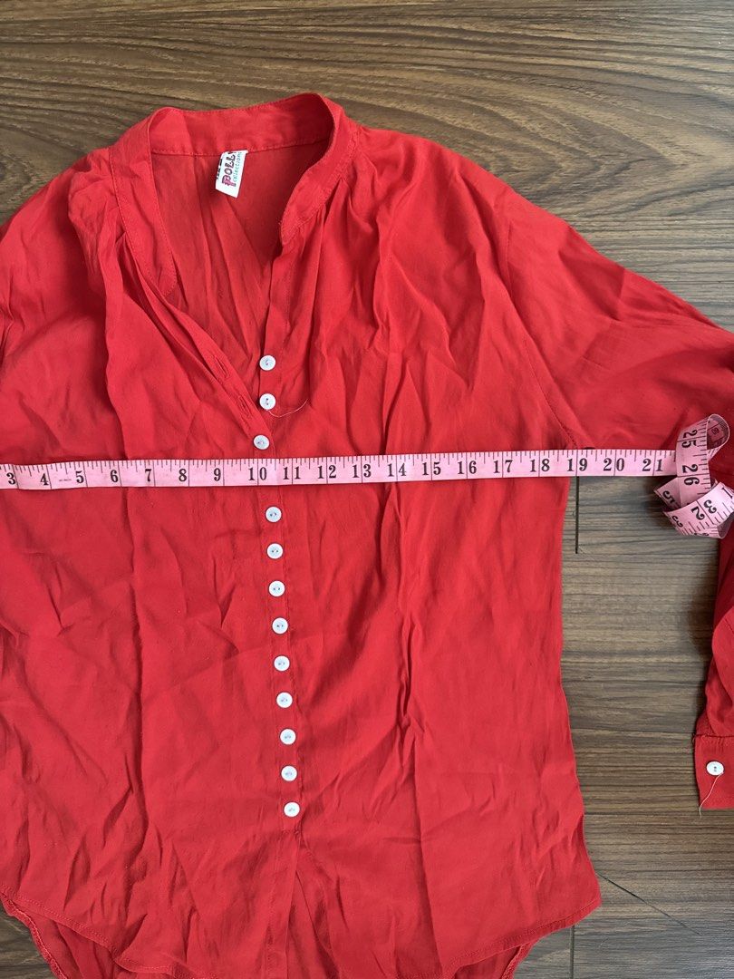 Polly Collections Red Button-Up Blouse (Category: Blouses) located in Rizal. Submitted by thrifty.mom (Listing ID 1464279820, Image 3). Description: - Red long-sleeved blouse - Brand: Polly Collections - V-neck with button-up front - Curved hemline - Measurements: Pit to pit approx 21 inches, length approx 30 inches - Ideal for casual wear.