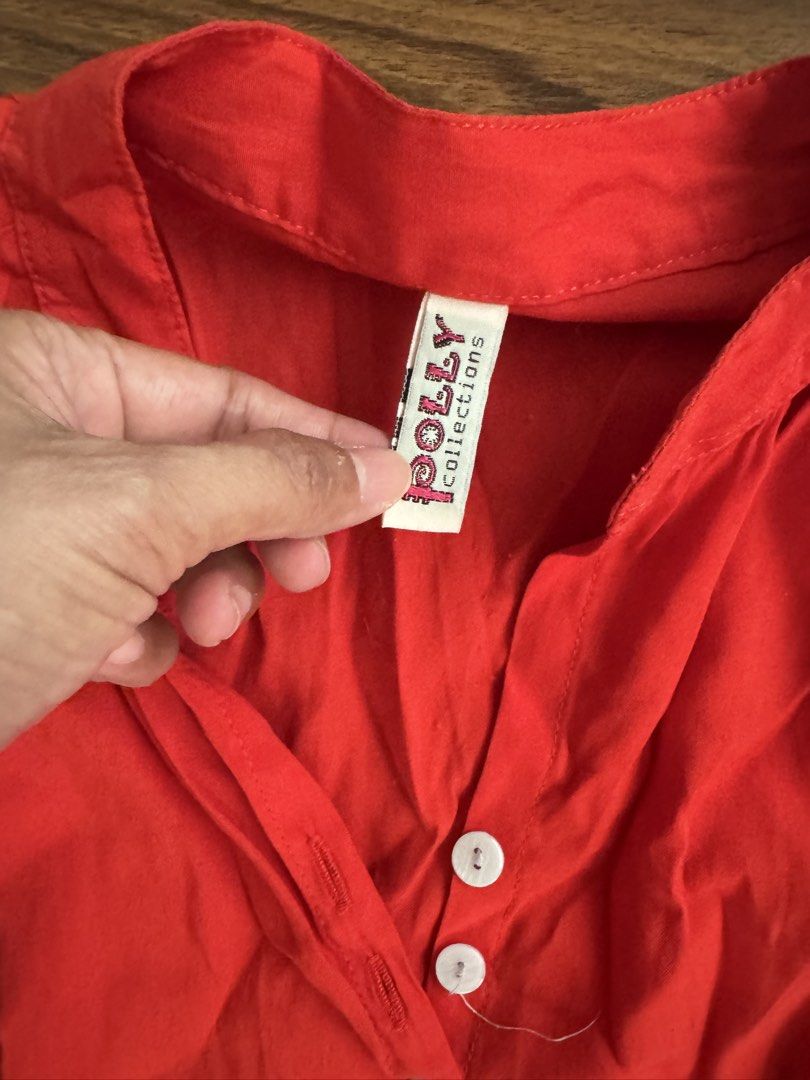 Polly Collections Red Button-Up Blouse (Category: Blouses) located in Rizal. Submitted by thrifty.mom (Listing ID 1464279820, Image 2). Description: - Red long-sleeved blouse - Brand: Polly Collections - V-neck with button-up front - Curved hemline - Measurements: Pit to pit approx 21 inches, length approx 30 inches - Ideal for casual wear.