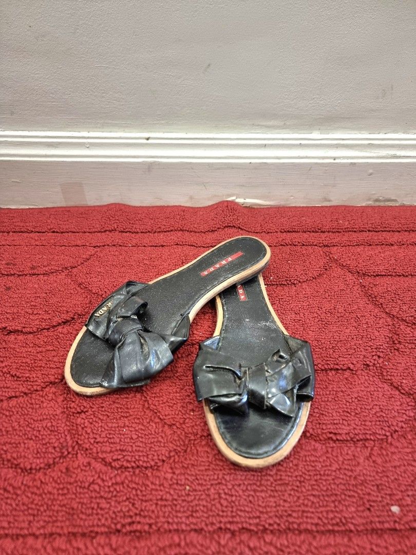 Prada Black Bow Slide Sandals (Category: Flats & Sandals) located in Manila. Submitted by pickmemanila (Listing ID 1464147137, Image 1). Description: - Brand: Prada - Style: Slide sandals - Color: Black - Feature: Cute bow detail on the front - Design: Slip-on, easy to wear - Condition: Soles show some wear - Occasion: Great for casual outings.