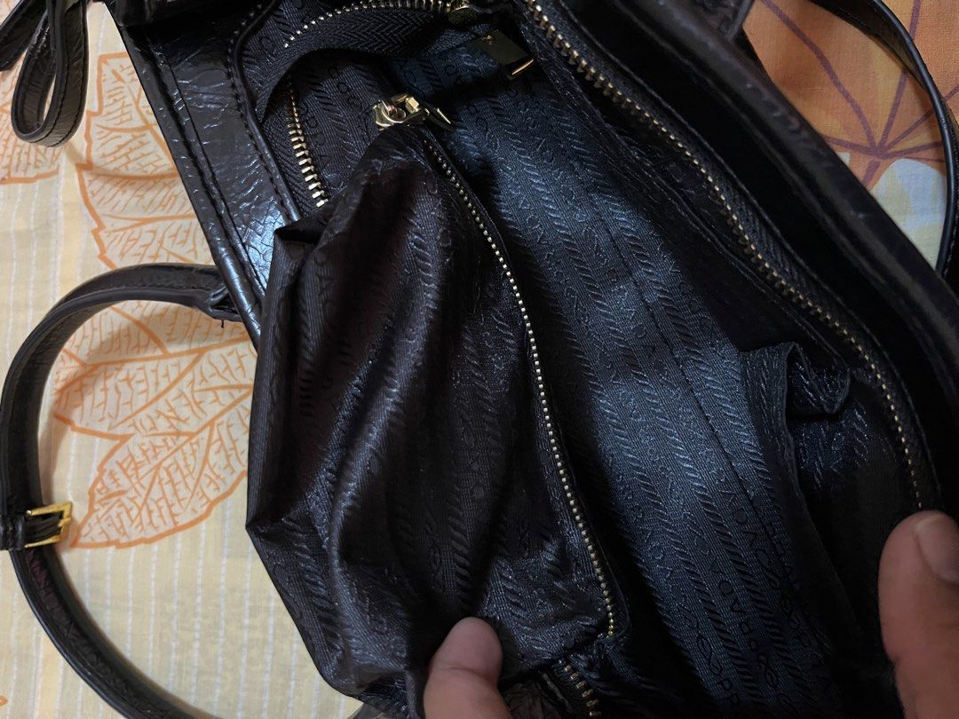 Prada Black Leather Handbag with Shoulder Strap (Category: Luxury Bags & Wallets) located in Quezon City. Submitted by reluxefinds2025 (Listing ID 1464179106, Image 3). Description: - Authentic Prada handbag, Made in Italy - Features elegant top handles - Includes a detachable shoulder strap for versatility - Accented with luxurious gold hardware - Interior zippered pocket for secure storage - Lined with signature Prada logo fabric - Ample space 