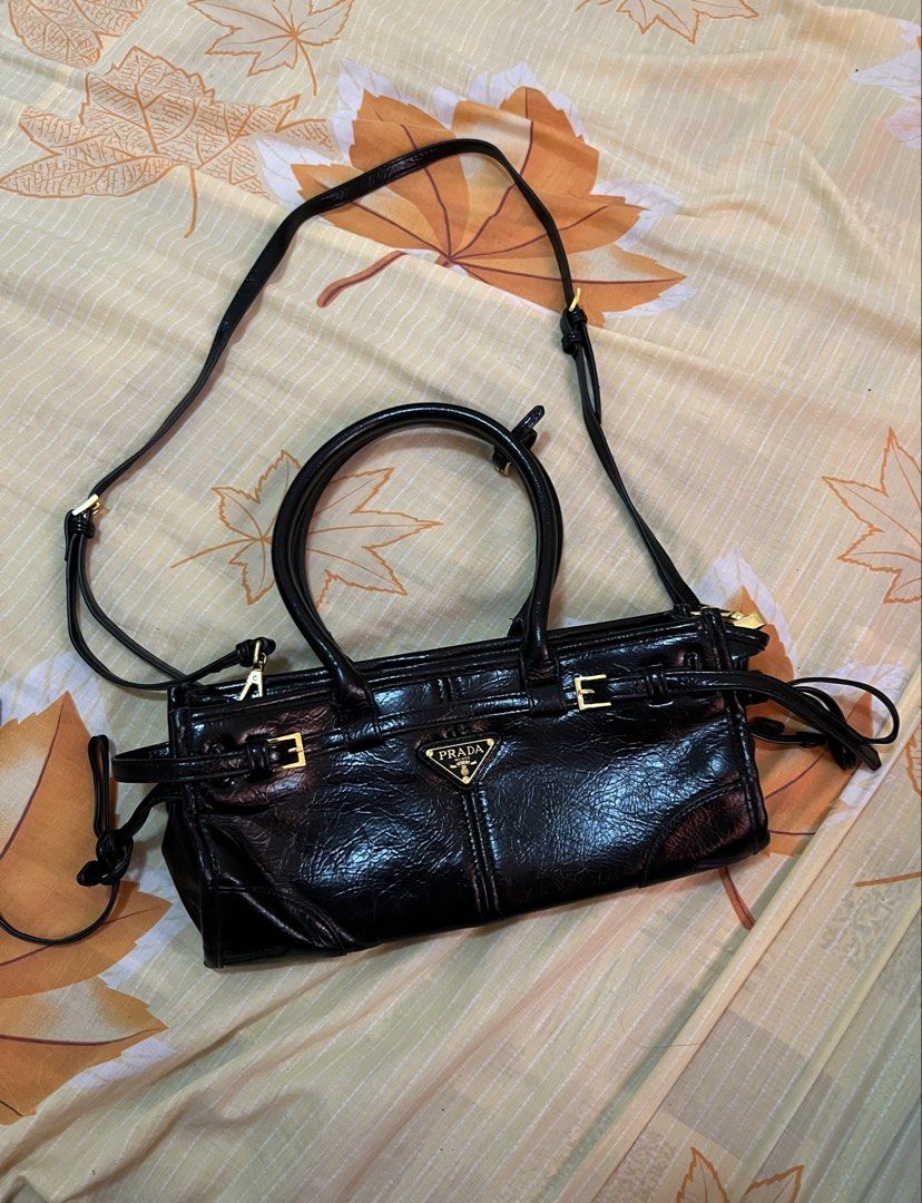 Prada Black Leather Handbag with Shoulder Strap (Category: Luxury Bags & Wallets) located in Quezon City. Submitted by reluxefinds2025 (Listing ID 1464179106, Image 1). Description: - Authentic Prada handbag, Made in Italy - Features elegant top handles - Includes a detachable shoulder strap for versatility - Accented with luxurious gold hardware - Interior zippered pocket for secure storage - Lined with signature Prada logo fabric - Ample space 