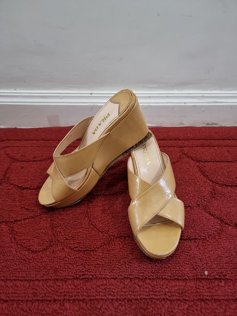Prada Patent Leather Wedge Sandals (Category: Flats & Sandals) located in Manila. Submitted by pickmemanila (Listing ID 1464145649, Image 1). Description: - Authentic Prada wedge sandals - Luxurious patent leather finish - Elegant beige/tan color - Stylish criss-cross strap design on the vamp - Open toe for a breezy feel - Comfortable wedge heel - Shows minor scuffs on leather and soles from normal use.