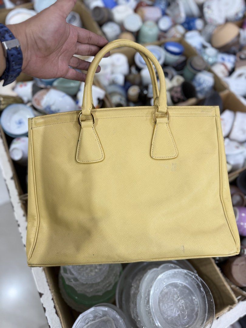 Prada Saffiano Leather Tote Bag Yellow (Category: Luxury Bags & Wallets) located in Bacolod City. Submitted by kitcarsonduff (Listing ID 1464269551, Image 2). Description: - yellow Prada tote bag - Made from durable Saffiano leather - Elegant gold hardware details - Interior zippered pocket for essentials - Includes a leather tag - Minor signs of wear on the exterior - Ideal for everyday use.