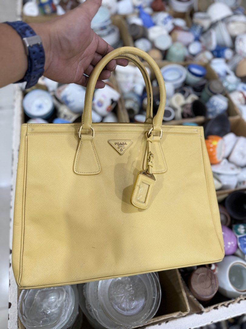 Prada Saffiano Leather Tote Bag Yellow (Category: Luxury Bags & Wallets) located in Bacolod City. Submitted by kitcarsonduff (Listing ID 1464269551, Image 1). Description: - yellow Prada tote bag - Made from durable Saffiano leather - Elegant gold hardware details - Interior zippered pocket for essentials - Includes a leather tag - Minor signs of wear on the exterior - Ideal for everyday use.