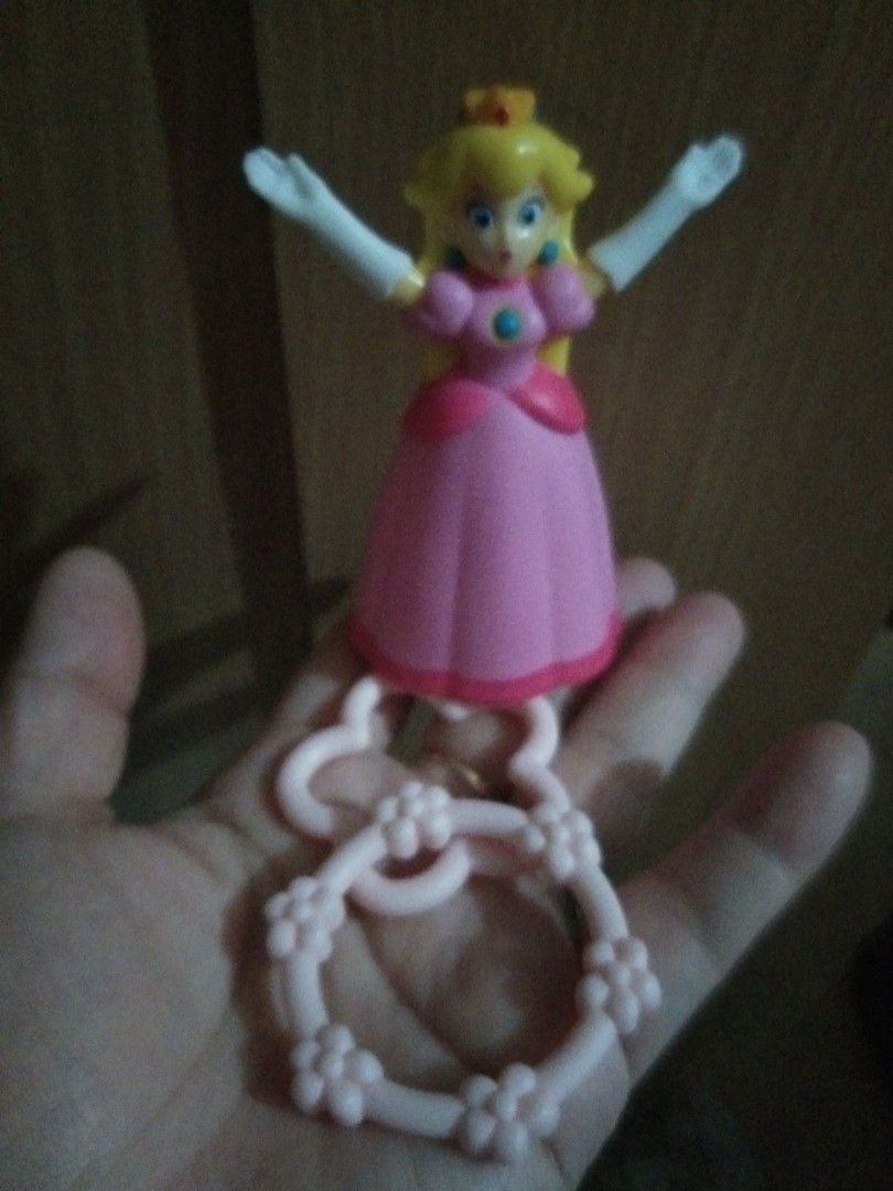 Princess Peach hoop Toy Figure (Category: Character Goods) located in Quezon City. Submitted by eidorableshop (Listing ID 1464280054, Image 2). Description: - Adorable Princess Peach toy with keychain attachment. - Features a charming pink and yellow color scheme. - Princess Peach is dressed in her iconic pink dress and white gloves. - The keychain itself is pink and adorned with lovely flower details. - Ideal for fans of the popular game series.