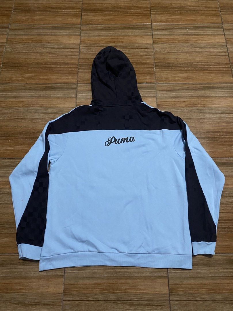 Puma Light Blue "00" Graphic Hoodie (Category: Hoodies) located in Baguio. Submitted by arenzu (Listing ID 1464302743, Image 3). Description: - Light blue Puma hoodie with black accents. - Features a '00' graphic and 'Overly Determined to Dominate' text on the front. - Checkerboard pattern on sleeves and hood. - Puma logo detail on the back. - Includes drawstring hood and a convenient front pocket..