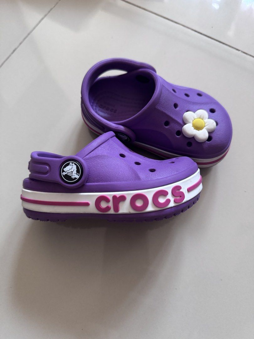 Purple Crocs with Flower Charm (Category: Babies & Kids Fashion) located in Quezon City. Submitted by jonahmprz (Listing ID 1464213066, Image 1). Description: -Original Crocs for baby -Size c5, bought in UK - Adorable purple Crocs for kids - Features a cute flower charm on the front - Easy slip-on design for quick wear - Durable and comfortable for playtime and casual outings - Iconic Crocs logo detail on side and sole.
