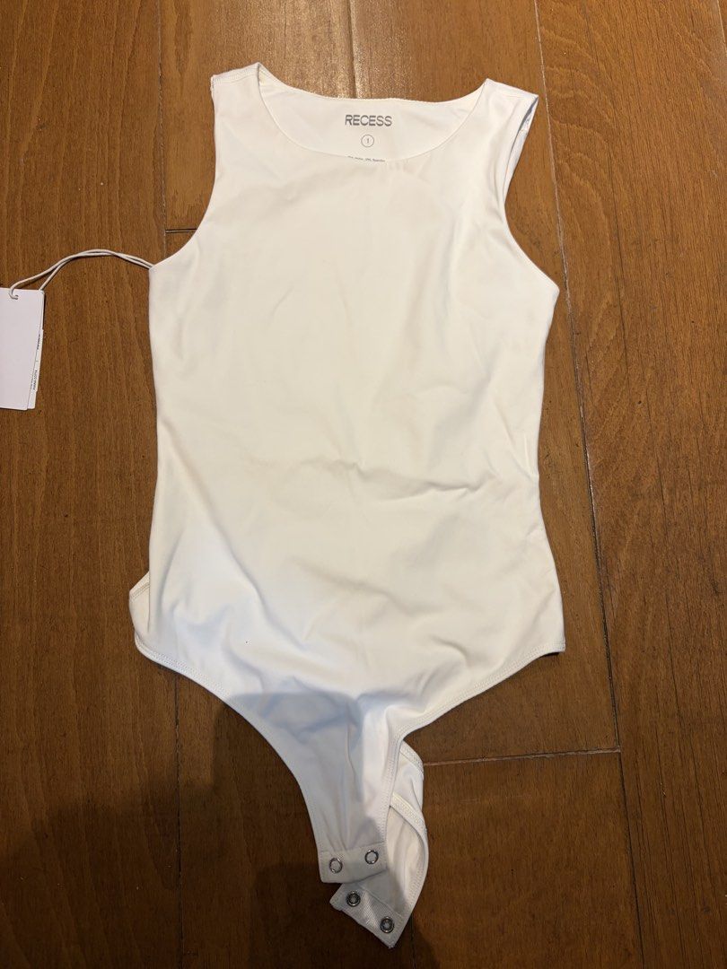 Recess The 90s Called Bodysuit white xs (Category: Blouses) located in Muntinlupa City. Submitted by secondhandlove12345 (Listing ID 1464276239, Image 1). Description: - Recess The 90s Called Bodysuit - Color: Panna Cotta - Size: 1 - Material: 75% Nylon, 25% Spandex - Features: Comfortable and stretchy fabric, snap closure at the bottom - Versatile: Great for layering or wearing on its own.