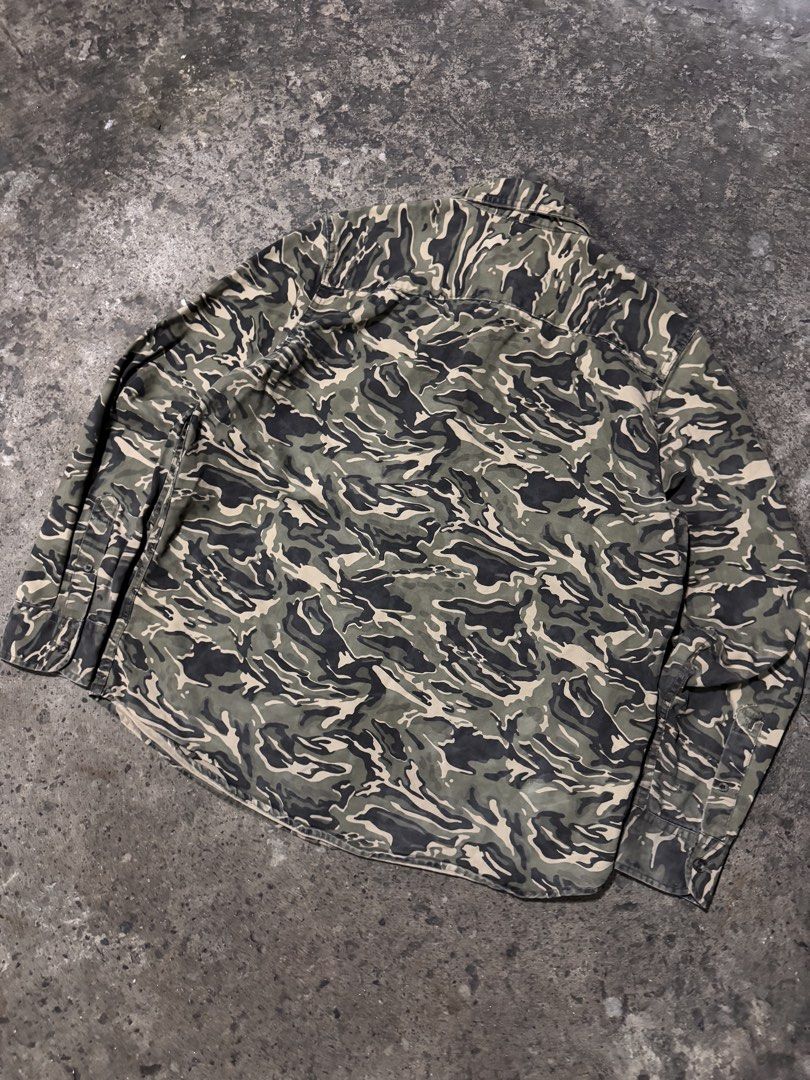 Roebuck & Co. Camouflage Button-Up Shirt (Category: Tshirts & Polo Shirts ) located in Pasig City. Submitted by dripthrift1600 (Listing ID 1464247420, Image 2). Description: - Brand: Rocawear & Co. - Style: Camouflage button-up shirt - Sleeves: Long sleeves with button cuffs - Pockets: Two chest pockets with button closures - Closure: Button-down front - Occasion: Great for casual wear - Condition: Please check photos for details - Dimes: 23x28.