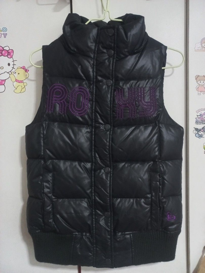 Roxy Black Puffer Vest with Hood Size S (Category: Coats, Jackets and Outerwear) located in Manila. Submitted by maryjoyenc89891 (Listing ID 1464244719, Image 3). Description: - Black Roxy puffer vest - Attached hood for extra warmth - Signature purple Roxy logo on the front - Ribbed cuffs ensure a snug and comfortable fit - Quiksilver branding visible on the inside tag - Ideal for layering over other clothing - Please check photos for detailed c