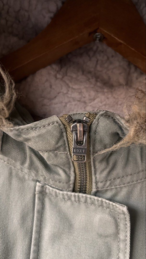 Roxy Green Fur Hooded Bomber Jacket Size M (Category: Coats, Jackets and Outerwear) located in Cabuyao City. Submitted by bulandos (Listing ID 1464233988, Image 3). Description: - Olive green Roxy jacket - Cozy fur-lined hood - Zip-up front with button closure - Two front pockets - Zippered sleeve pocket - Soft fleece lining - Ideal for cooler weather.