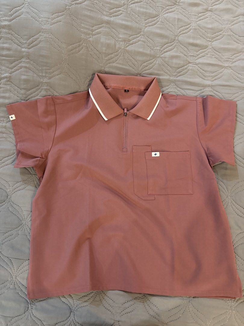 Scrub top (Category: Coats, Jackets and Outerwear) located in Quezon City. Submitted by rtysell (Listing ID 1464241654, Image 1). Description: - Rose pink polo shirt - Size S - Zip-up neckline - Chest pocket with small logo detail - White trim on collar - Small logo detail on sleeve - Ideal for casual wear or work.