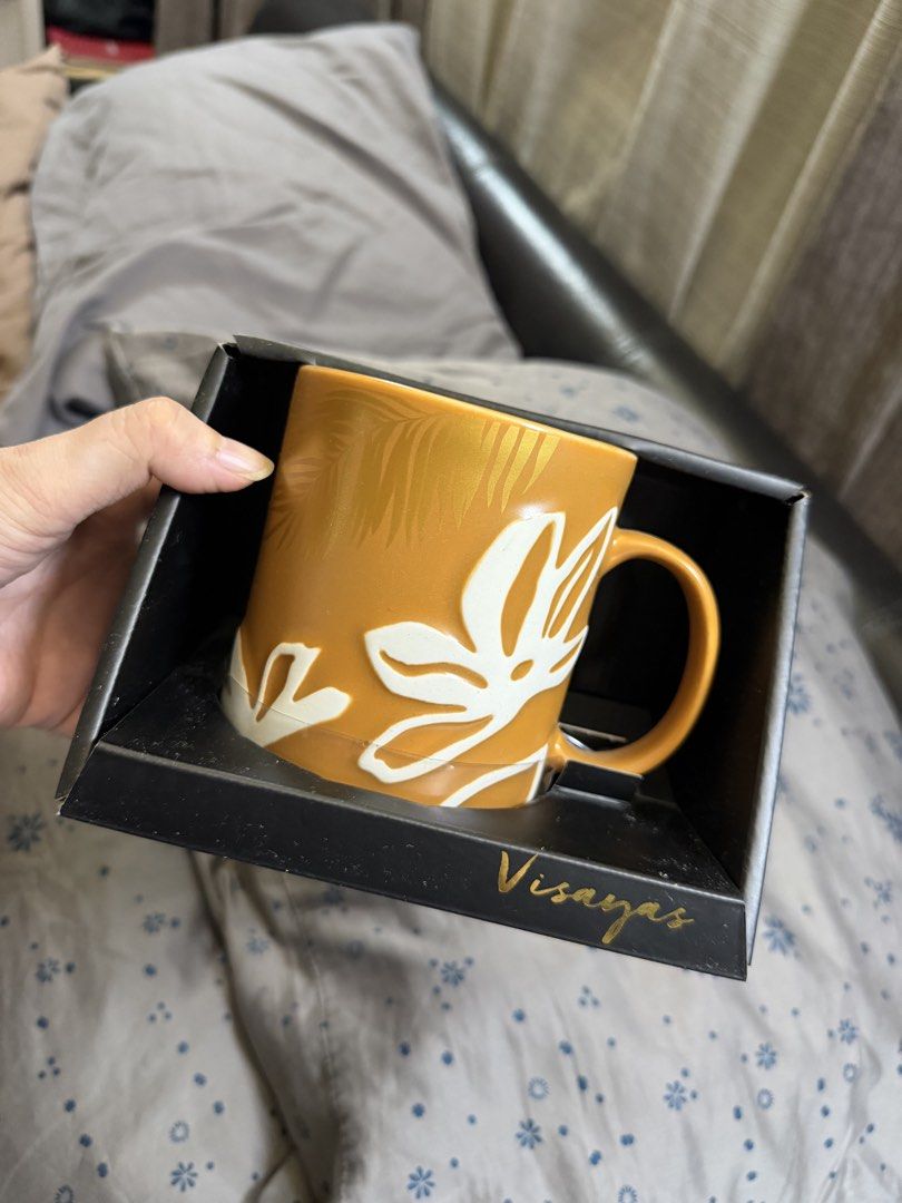 Starbucks Visayas Mug with Box (Category: Coffee & Tea Tableware) located in Quezon City. Submitted by ks_closet_cleaning (Listing ID 1464223257, Image 1). Description: - Authentic Starbucks mug - Vibrant orange color with elegant white floral design - Features 'Visayas' inscription on the inside - Includes original Starbucks box with leaf design (copyright 2018) - Ideal gift for coffee and tea enthusiasts.