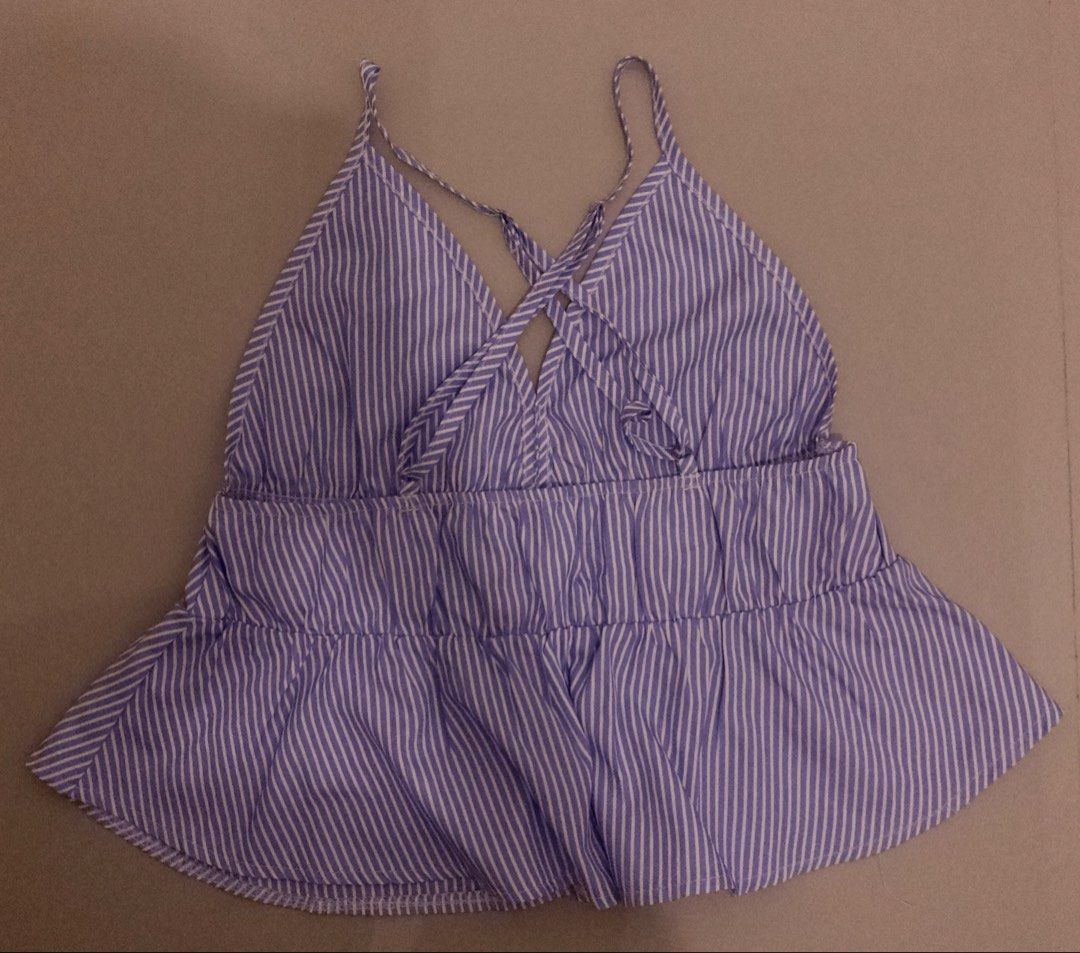Striped Backless Top (Category: Sleeveless) located in Rodriguez. Submitted by urforeverrina (Listing ID 1464317006, Image 2). Description: - Cute blue and white striped halter top from SHEIN - Features a ruffled hem - Criss-cross straps at the back - Size S - Ideal for casual outings or beach trips - Easy to pair with shorts or jeans.