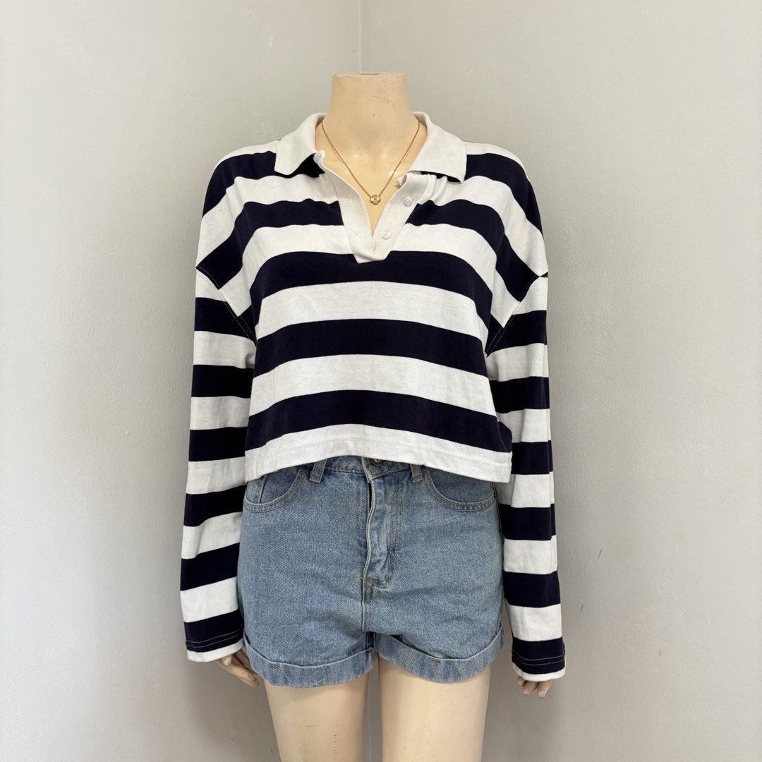 Stripes Crop Longsleeves Polo (Category: Longsleeves) located in Imus. Submitted by reloved.nd (Listing ID 1464253661, Image 1). Description: - Classic navy and white striped pattern - Cropped length - Long sleeves - Polo collar with button placket - Versatile for casual, preppy, or sporty looks - Pairs well with denim shorts or jeans - Comfortable and stylish.