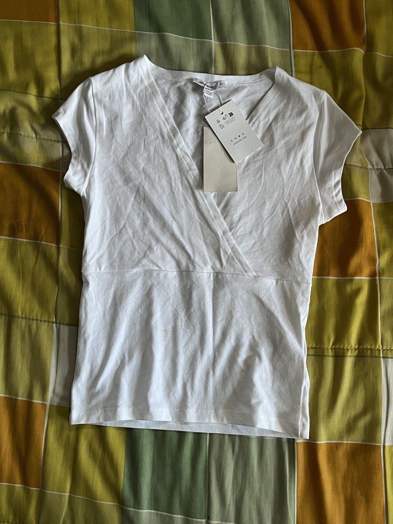 Subdued White Cross-neck Top with Tags (Category: Blouses) located in Manila. Submitted by thebeau.ph (Listing ID 1464222549, Image 1). Description: - White wrap top - V-neckline - Short sleeves - Brand new with original tags attached - Simple and classic design - Perfect for layering or wearing on its own.