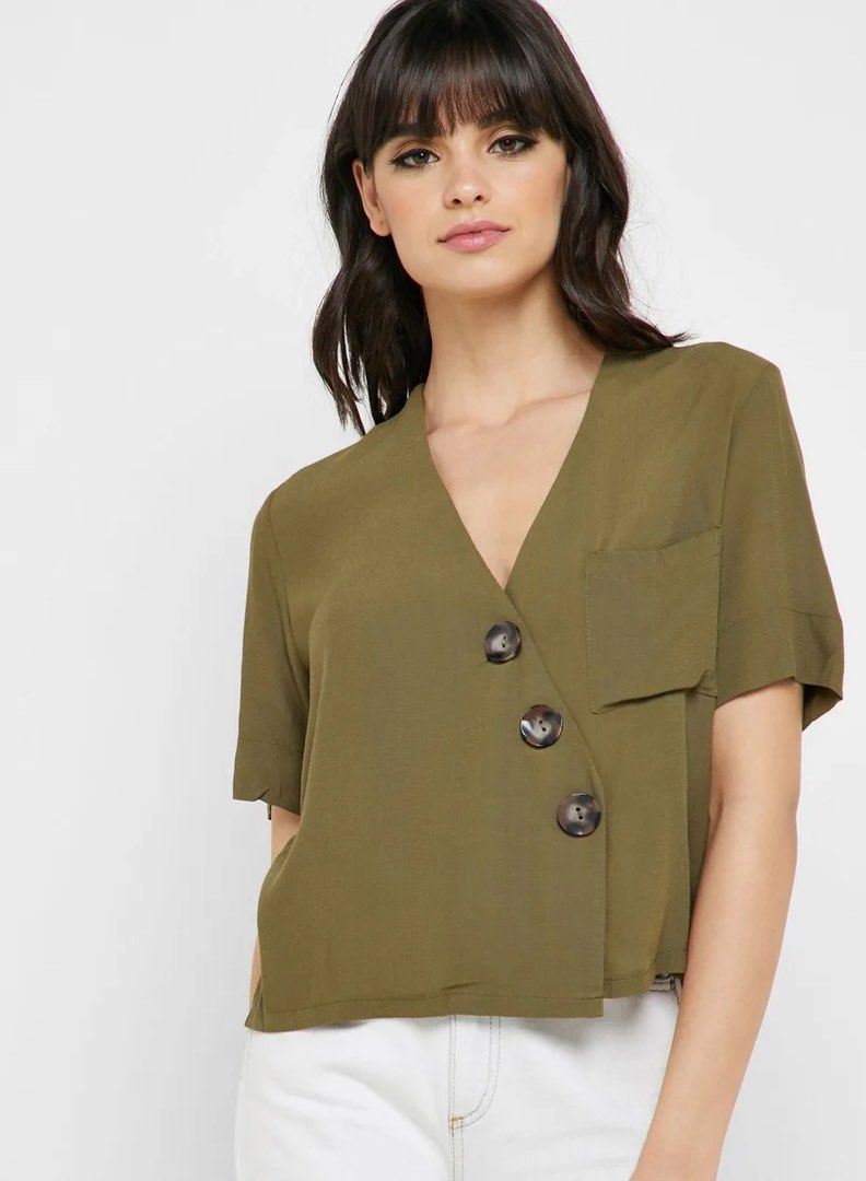TOPSHOP Olive Green Cropped Button Front Shirt Top (Category: Shirts) located in Munoz. Submitted by Liiz27 (Listing ID 1464260163, Image 1). Description: - Olive green cropped shirt - Brand: Topshop - V-neckline - Button-front closure - Single chest pocket (left side) - Short sleeves with cuffed hem - Versatile: pairs well with high-waisted bottoms.