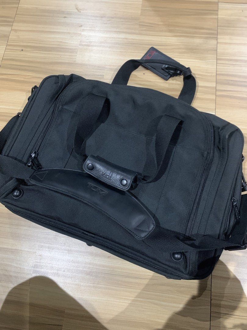 Tumi Black Nylon Duffle Travelling Bag (Category: Luxury Bags & Wallets) located in Polomolok. Submitted by domingthriftclothes (Listing ID 1464309106, Image 2). Description: - Durable black nylon construction - Genuine leather handles and strap - Multiple zippered compartments for excellent organization - Detachable shoulder strap included - Comes with a luggage tag - Ideal for both work and travel needs - Ample space for all your essentials.