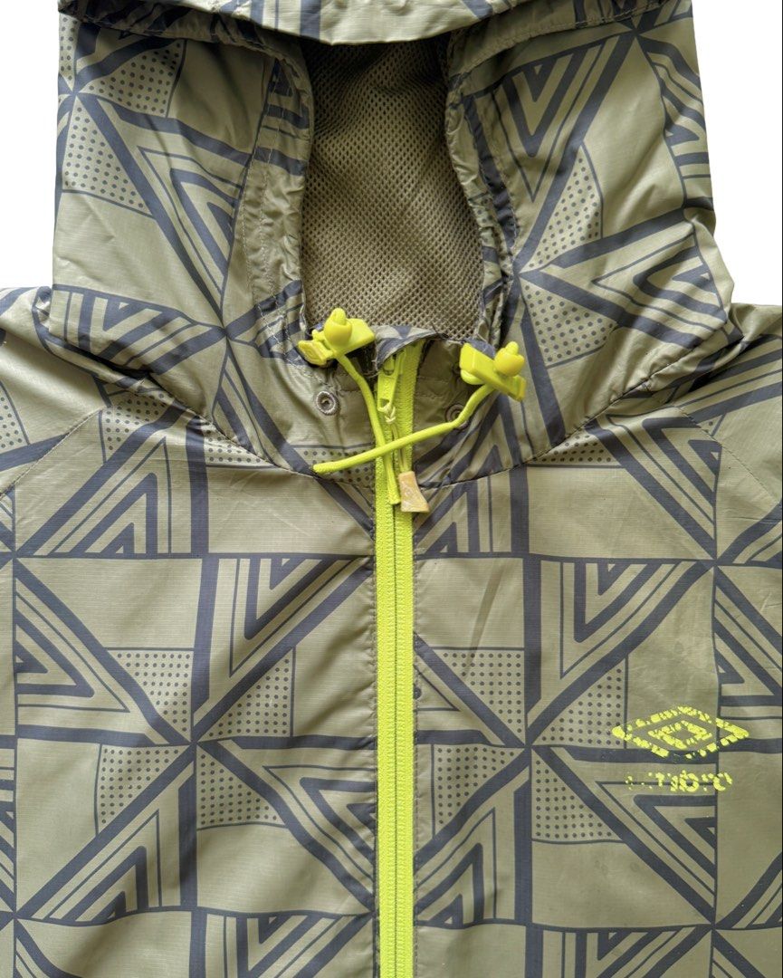 Umbro Packable Windbreaker (Category: Coats, Jackets and Outerwear) located in Manila. Submitted by morf_sply (Listing ID 1464304308, Image 3). Description: High collar with adjustable hood and visor made with weatherproof outer layer protection. Logo on the chest. Long sleeves with elasticated cuffs. Elasticated hem at the sides. Welt pockets. Medium on tag. Shoulder Width 18 in Pit to Pit 22 in Length 26 in Sleeves 25 in.