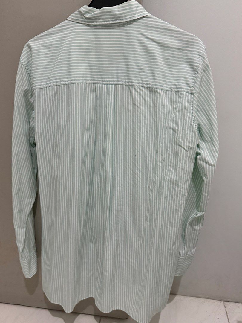 Uniqlo Striped Button-Up Shirt Size M (Category: Tshirts & Polo Shirts ) located in Mandaluyong City. Submitted by trovebya (Listing ID 1464236047, Image 2). Description: - Uniqlo Button-Up Shirt - Color: Light Green with White Pinstripes - Size: Medium (M) - Style: Long sleeves, collared - Versatile: Great for casual outfits or as a layering piece - Easy to style.