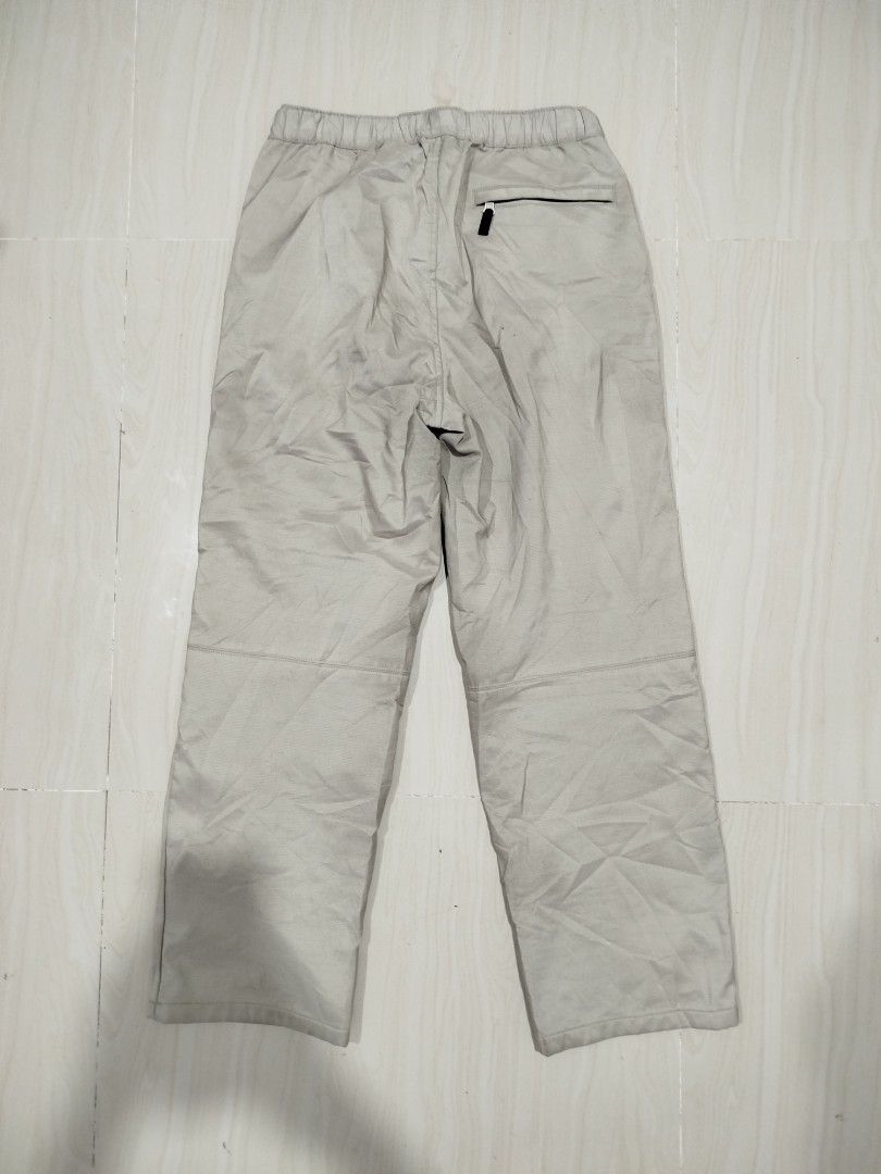Uniqlo Waterproof geared pants (Category: Trousers) located in Aroroy. Submitted by dr0p-a-dr1p (Listing ID 1464207048, Image 2). Description: Waist: 30-32 Length: 40 - Waterproof - Hardshell - Uniqlo beige pants - Elastic waistband with black buckle detail - Zippered pocket on the back - Subtle grid pattern material - Ideal for casual wear.