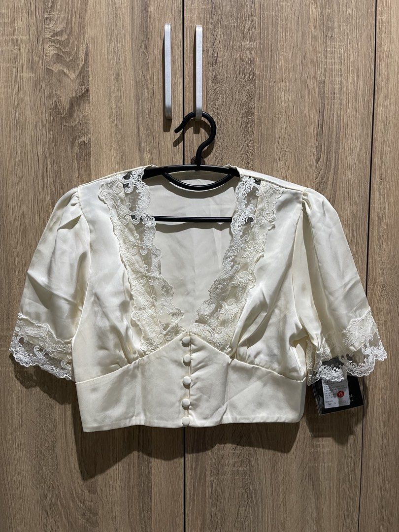 V Neck White Lace Trimmed Cropped Top (Category: Sleeveless) located in Manila. Submitted by preloveditems_jem (Listing ID 1464301699, Image 2). Description: Chic white cropped top with V-neck, button-up front, and puff sleeves. Features delicate lace details on neckline and sleeves..
