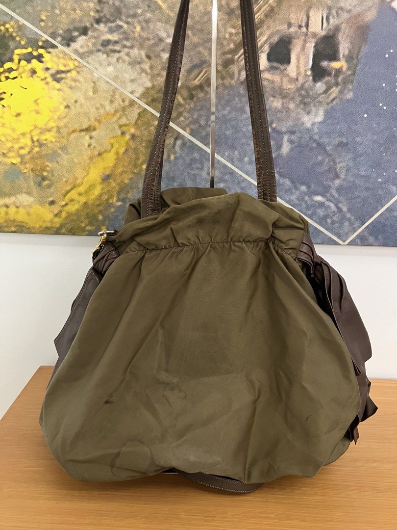 Vintage Prada Nylon & Leather Drawstring Hobo Bag Olive Green (Category: Luxury Bags & Wallets) located in Manila. Submitted by pearlt455 (Listing ID 1464244183, Image 2). Description: - Authentic Vintage Prada Tessuto Nylon Drawstring Tote bag - Color: Olive green nylon with brown leather accents - Closure: Drawstring - Condition: Well-Used - Leather straps show some wear, faint marks on exterior nylon, interior lining is clean (please see photo