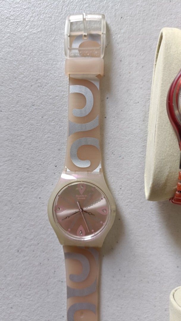 Vintage Swatch Pearly Tears 38mm (Category: Luxury Watches) located in Quezon City. Submitted by unusual_knicknacks (Listing ID 1464264471, Image 1). Description: - Swatch watch with a light pink pearlescent face - Translucent pink strap with repeating silver swirl pattern - Clear plastic buckle closure - A fun and stylish accessory.