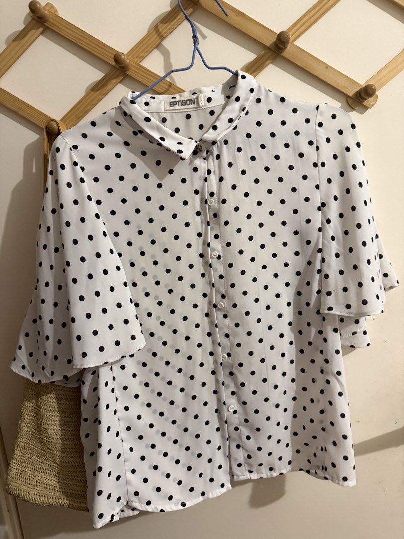 White Black Polka Dot Blouse (Category: Blouses) located in San Fernando. Submitted by richeloy (Listing ID 1464138366, Image 1). Description: - Classic white blouse with timeless black polka dots. - Features a button-up front and a smart collar. - Delicate flutter sleeves add a touch of femininity. - Lightweight material, ideal for staying cool in warmer climates. - Effortlessly pairs with jeans or skirts for a versatile look. - Suitable for bot
