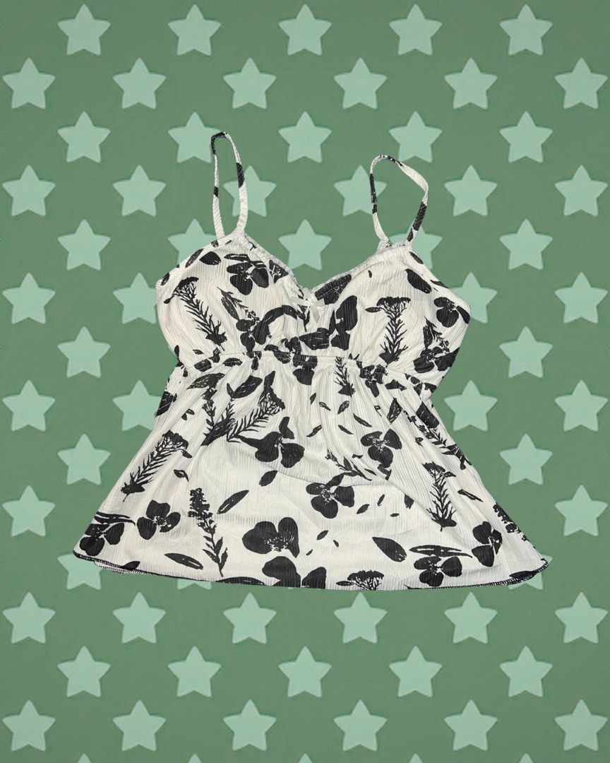 White cami top with black floral print (Category: Sleeveless) located in Tuguegarao City. Submitted by love_clothies (Listing ID 1464246812, Image 1). Description: - Cute white cami top - All-over black floral print - Ribbed fabric texture - Adjustable straps - Versatile for layering or wearing on its own - Easy to pair with jeans or shorts.