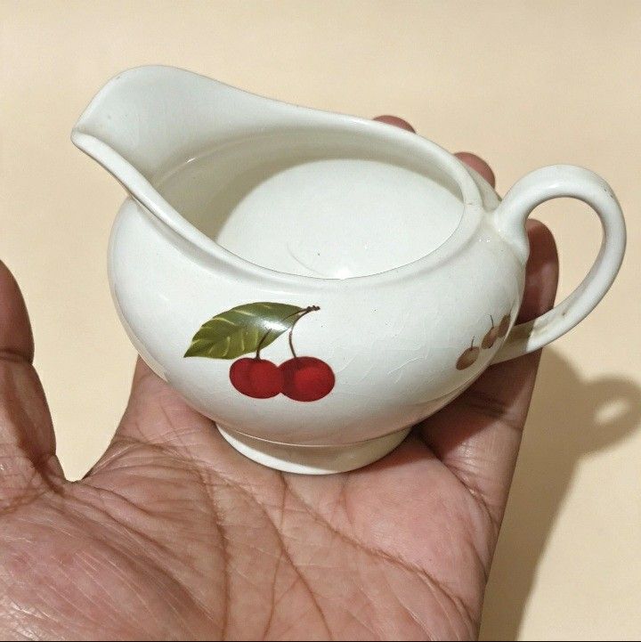 White Ceramic Creamer Pitcher with Cherry Design (Category: Coffee & Tea Tableware) located in Iligan City. Submitted by sariranaw (Listing ID 1464245387, Image 2). Description: - Adorable white ceramic creamer pitcher - Features a sweet cherry design - Includes a handle and spout for easy pouring - Small size, ideal for individual servings or as a decorative accent - Shows minor crazing on the glaze, consistent with age - Adds a charming touch t