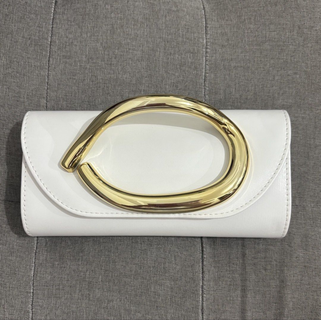 White Clutch Bag with Gold Handle (Category: Clutches) located in Pasay City. Submitted by keen.theesh_2026 (Listing ID 1464195313, Image 1). Description: - White clutch bag - Unique gold handle - Detachable gold chain strap included - Ideal for parties and nights out - Clean and chic design - Ready for its new owner.