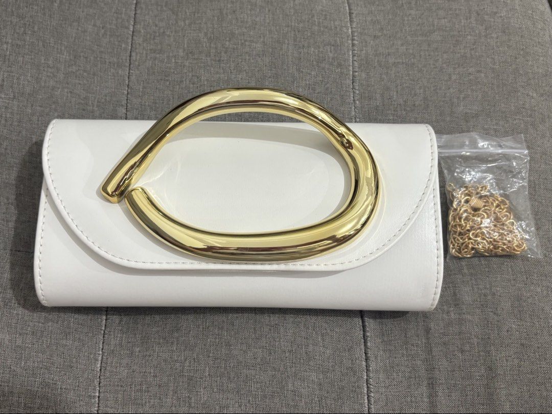 White Clutch Bag with Gold Handle (Category: Clutches) located in Pasay City. Submitted by keen.theesh_2026 (Listing ID 1464195313, Image 2). Description: - White clutch bag - Unique gold handle - Detachable gold chain strap included - Ideal for parties and nights out - Clean and chic design - Ready for its new owner.
